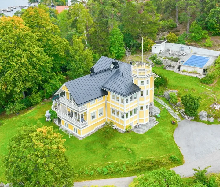 Gul villa med svart plåttak