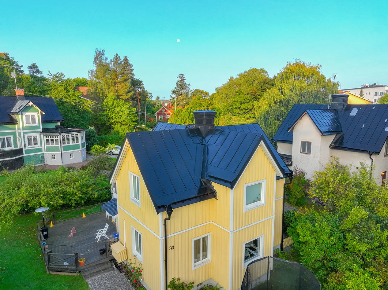 Gul villa med svart plåttak
